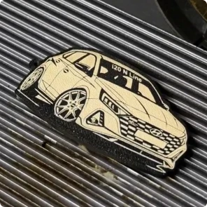 3Dプリンターで作成した柔軟性のあるTPU製キーホルダーに、レーザー刻印機を使って精細な車のデザインを彫刻するメイカー