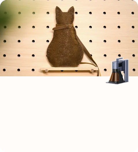 座っている猫をかたどった、手作りの革製収納ポーチ