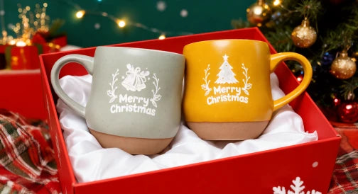 赤いギフトボックスに配置された、祝祭のイラストが刻印されたクリスマスをテーマにした陶器マグカップ